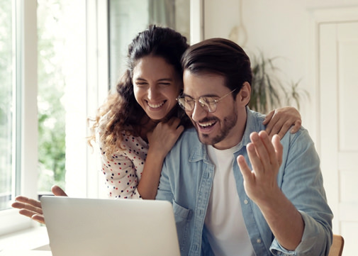 Happy couple looks into the display with home presentation